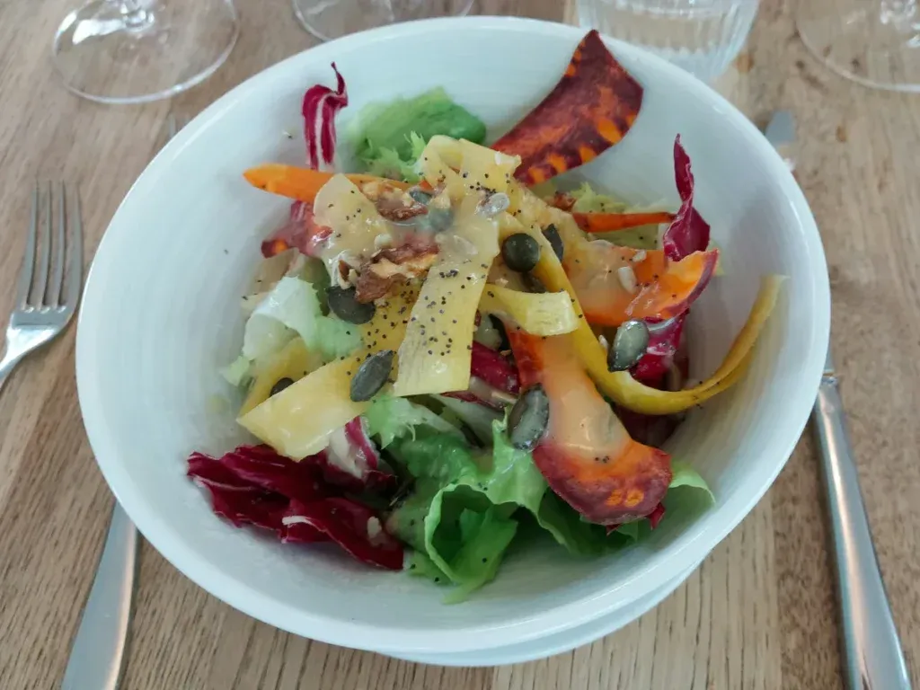 Marktsalat mit Blattsalaten, Karottenstreifen, cremigem Dressing und gerösteten Kürbiskernen im Bay Bern