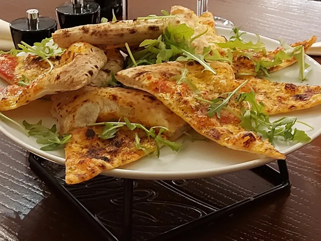 Pizza pieces with fresh rocket for sharing at Celina Bern