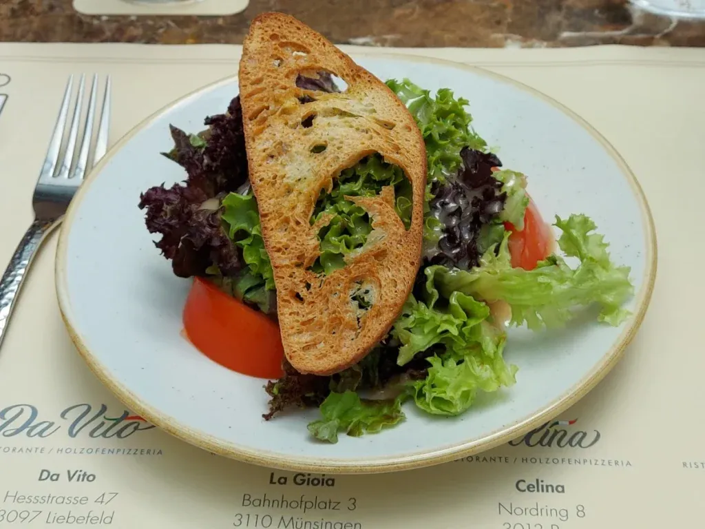 Mixed lollo salad with tomatoes and golden-brown toasted bread at Celina Bern