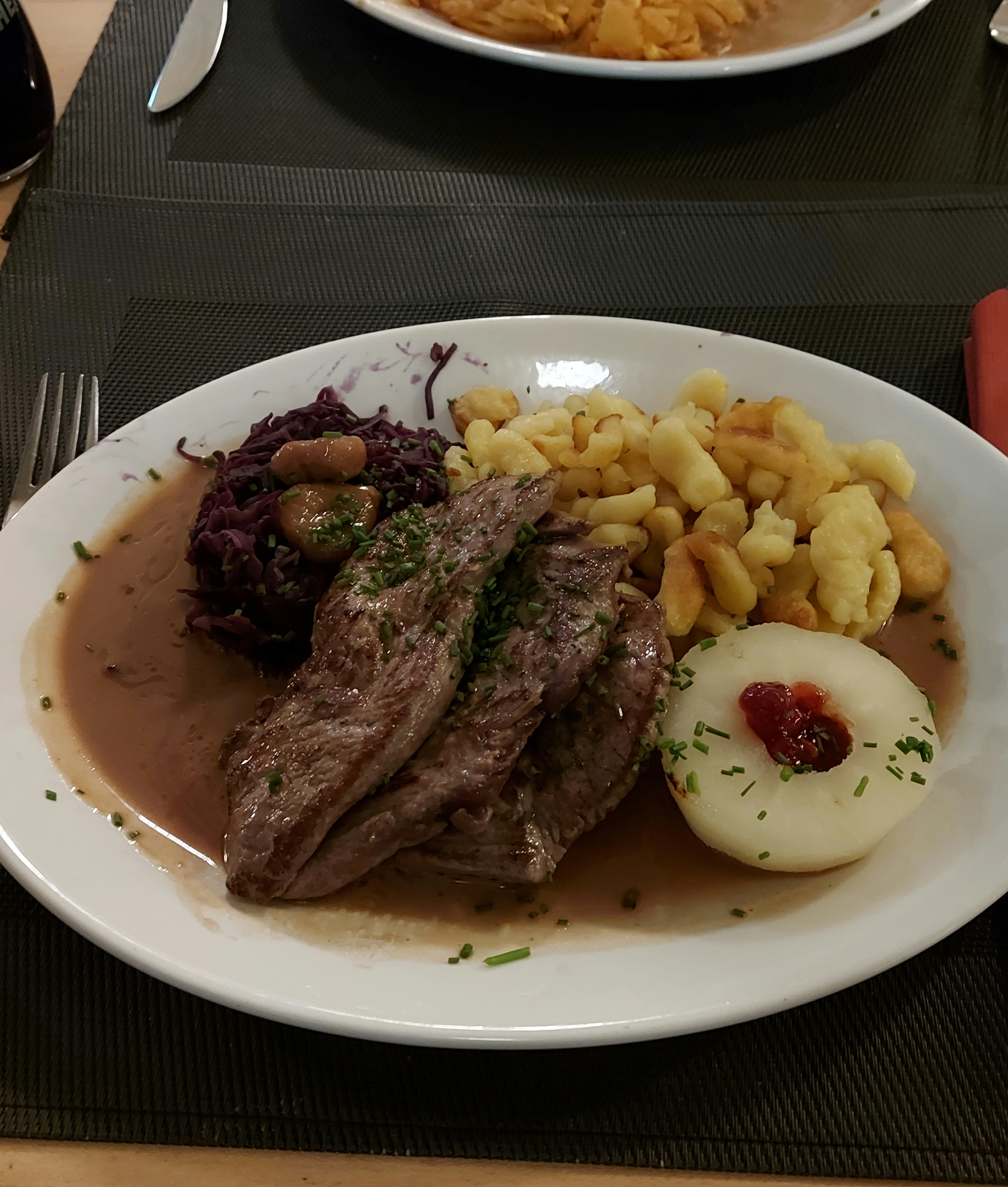 Traditional game platter with venison steaks, red cabbage, and spätzle at Restaurant Della Casa Bern.