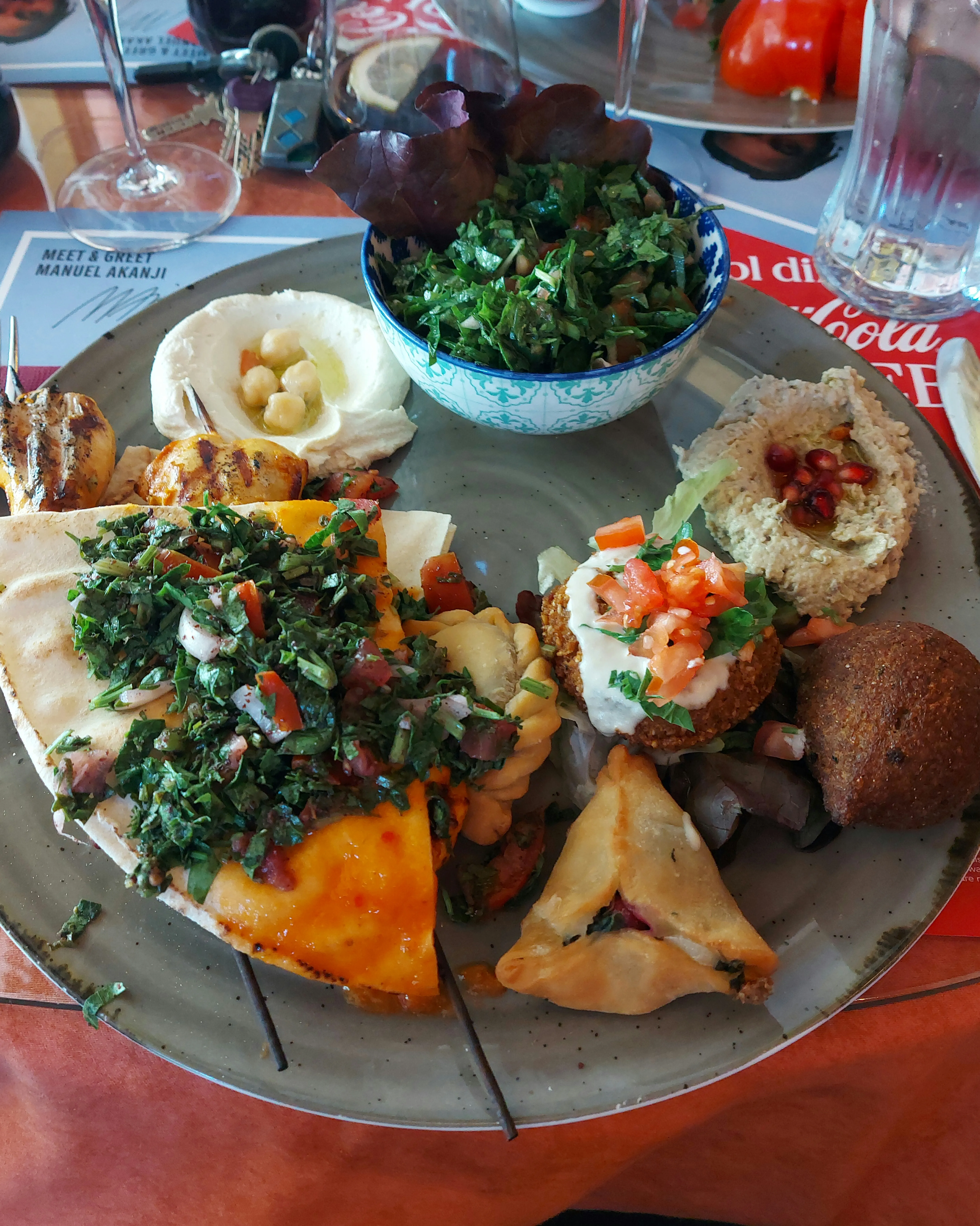 Domino Platter with sambussek, hummus, baba ganoush, kebbe, tabbouleh, falafel, spinach pastry, and chicken skewers at Domino Bern