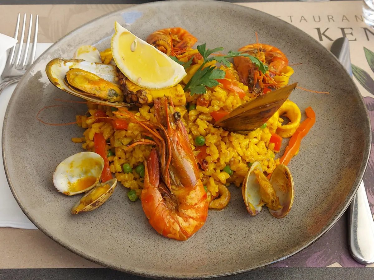 Paella with chorizo and seafood at Falken Bern – saffron-yellow rice with prawns, mussels, and calamari.