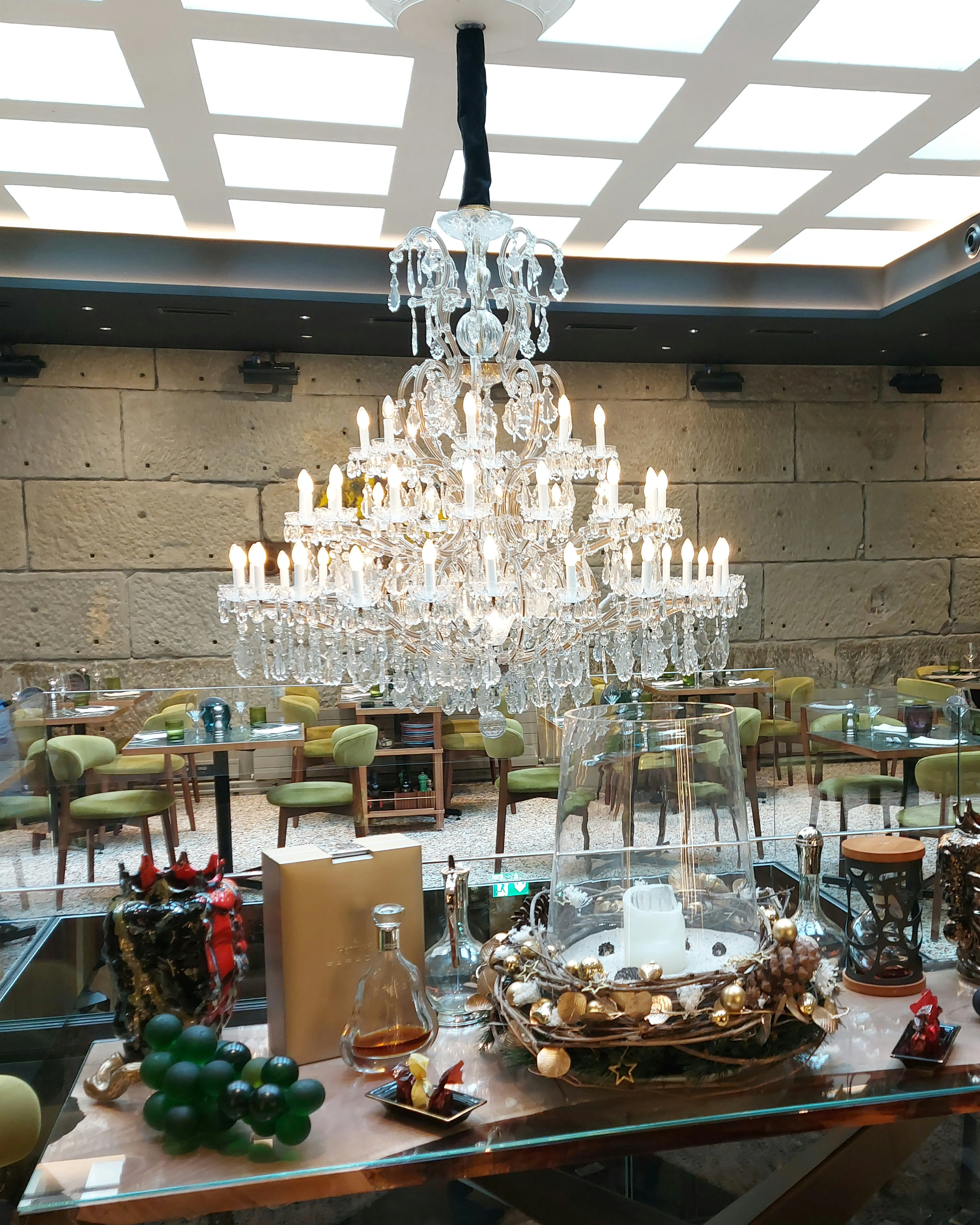 Innenraum der Galleria Luce Bern mit Kronleuchter, elegant gedeckten Tischen und stilvoller Beleuchtung
