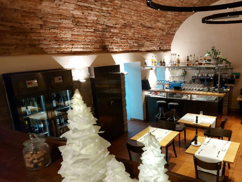Blick von oben in den Klötzlikeller Bern mit seinem imposanten Ziegelstein-Gewölbe, weiss gedeckten Tischen und moderner Bar