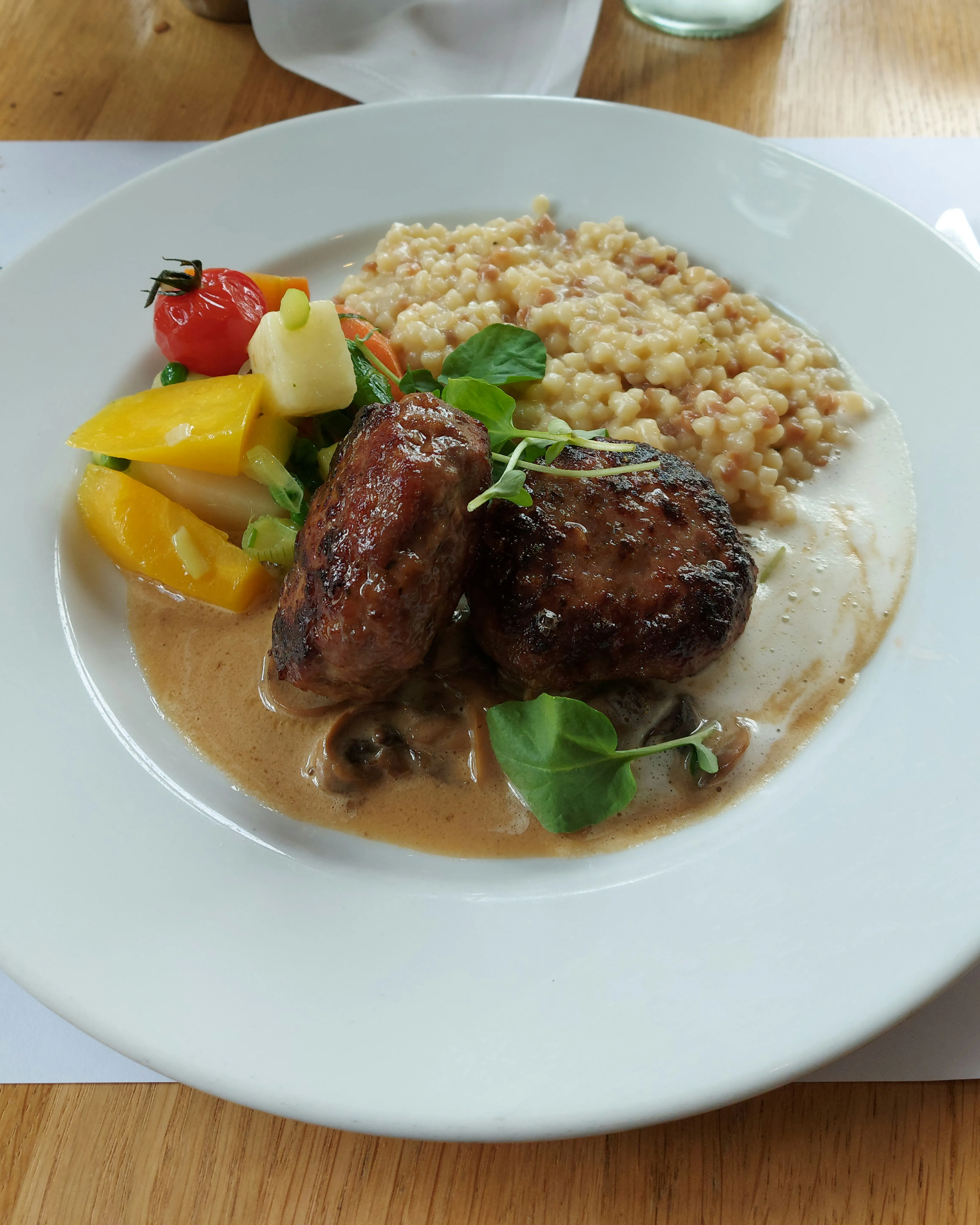 Swiss meat patties with mushroom cream sauce and Fregola Sarda at Süder Bern
